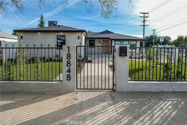 view of gate featuring a fenced front yard and a lawn