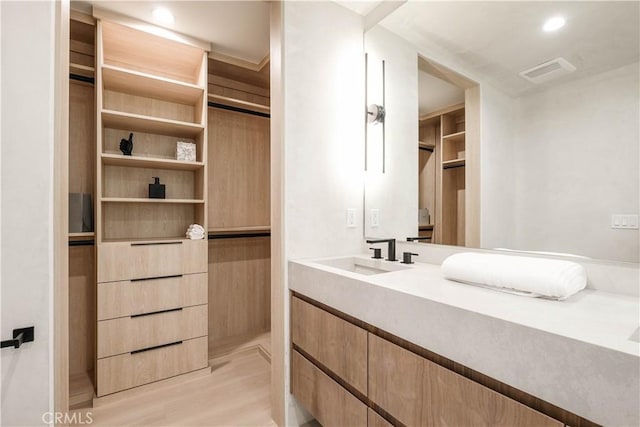 bathroom featuring visible vents, wood finished floors, vanity, a closet, and recessed lighting