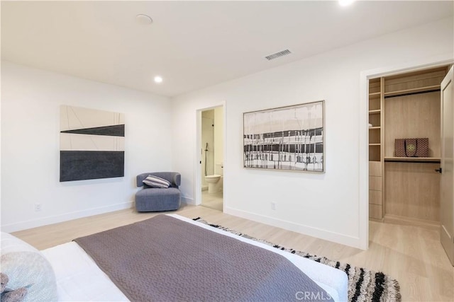 bedroom featuring recessed lighting, a walk in closet, visible vents, baseboards, and wood finished floors