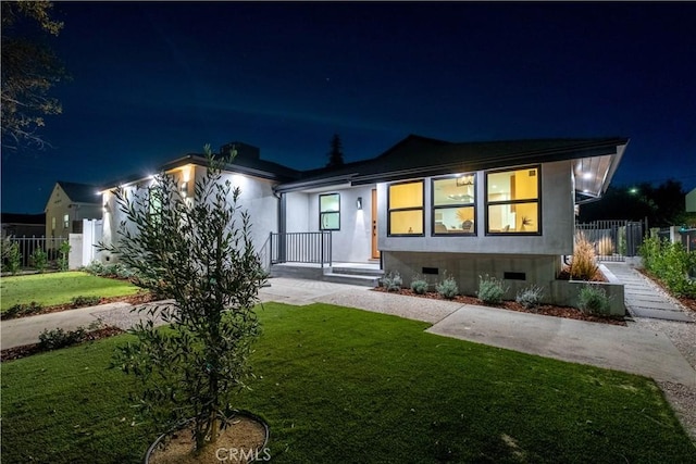 view of front of home featuring crawl space, fence, and a lawn