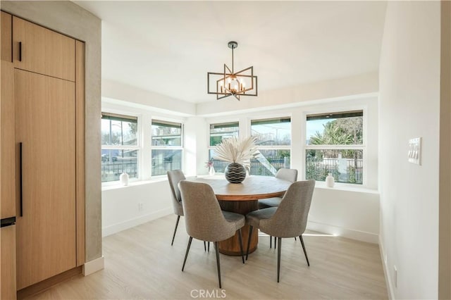 18848 Collins St, Tarzana, CA 91356 - dining room with light wood-style flooring, a chandelier, healthy amount of natural light, and baseboards