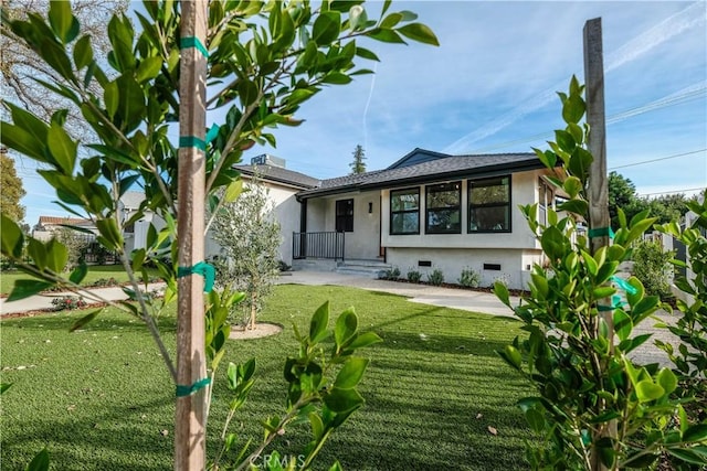 back of property featuring crawl space, a yard, a shingled roof, and stucco siding