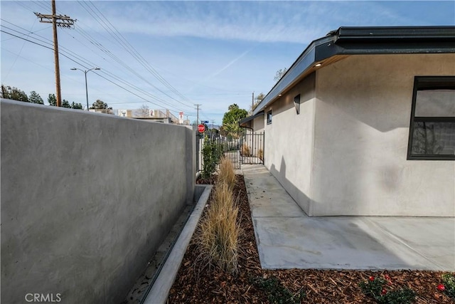 view of property exterior featuring fence and stucco siding