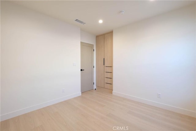 unfurnished room with baseboards, visible vents, light wood finished floors, and recessed lighting