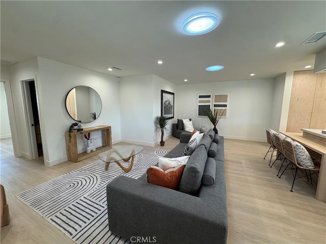 living area featuring baseboards, recessed lighting, visible vents, and light wood-style floors