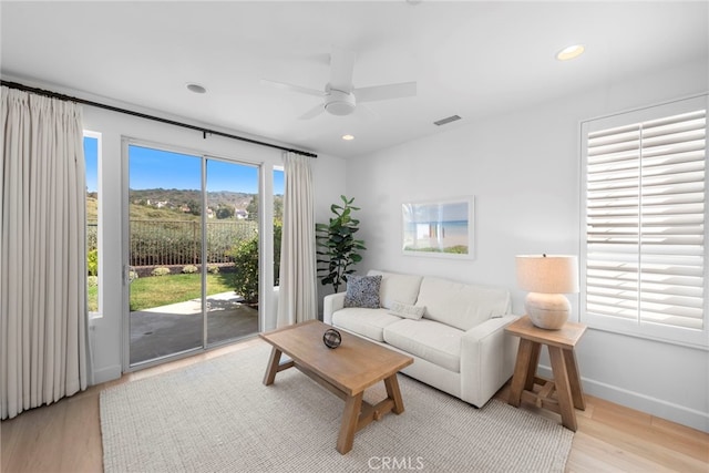 living room featuring light wood-type flooring and ceiling fan