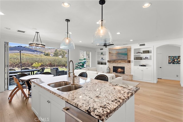 kitchen featuring white cabinetry, sink, dishwasher, and decorative light fixtures