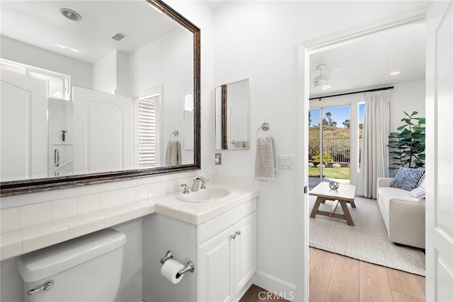 bathroom with hardwood / wood-style floors, vanity, and toilet