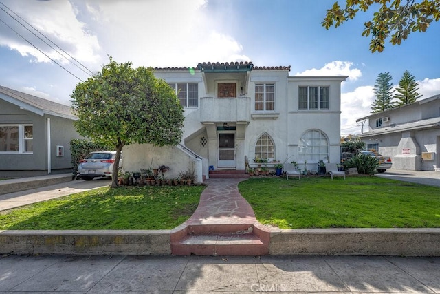 mediterranean / spanish-style house with a front lawn