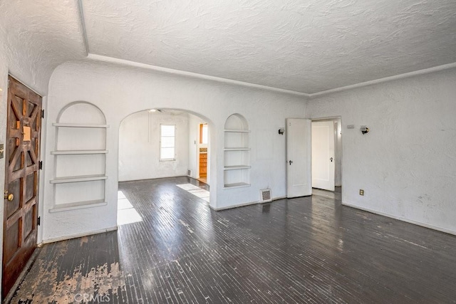 1314 E Harvard St, Glendale, CA 91205 - unfurnished living room with built in shelves, arched walkways, a textured ceiling, wood finished floors, and baseboards