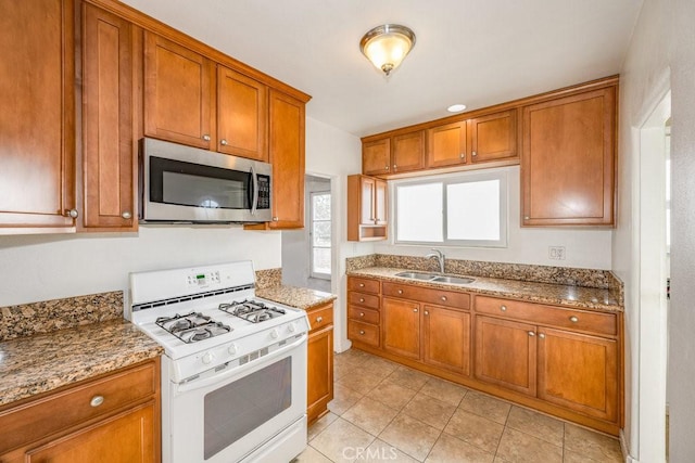 1314 E Harvard St, Glendale, CA 91205 - kitchen with stainless steel microwave, white gas stove, a sink, and brown cabinets