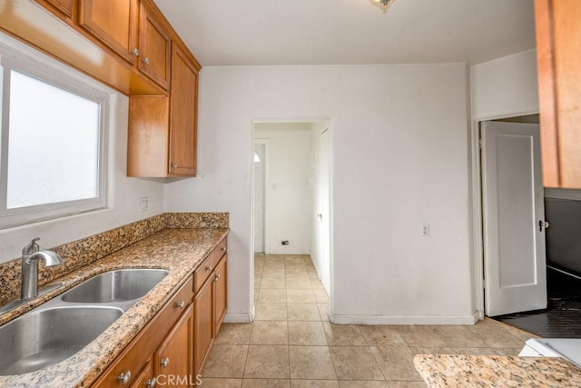 1314 E Harvard St, Glendale, CA 91205 - kitchen with a sink, brown cabinetry, light tile patterned flooring, stone counters, and baseboards
