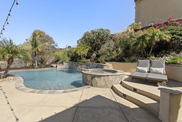 pool featuring a patio and an in ground hot tub