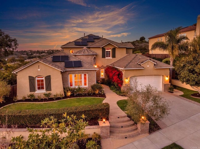 mediterranean / spanish house featuring a garage, a yard, driveway, and fence