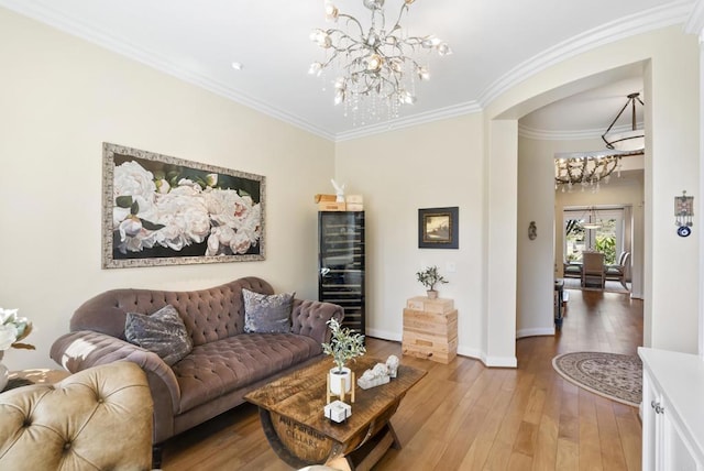 living area with light wood finished floors, baseboards, a chandelier, and crown molding