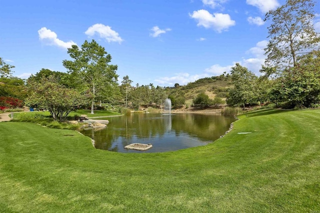 view of home's community with a yard and a water view