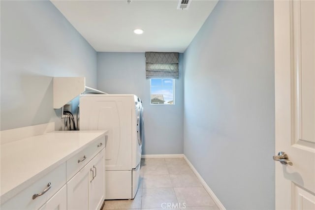 laundry area featuring light tile patterned flooring, cabinets, and washer / clothes dryer