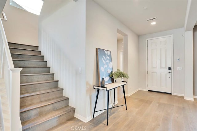 entrance foyer with a skylight and light hardwood / wood-style floors