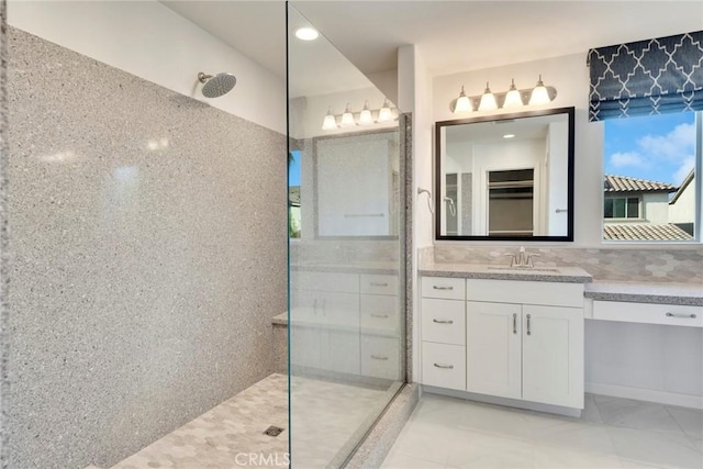 bathroom featuring tiled shower and vanity