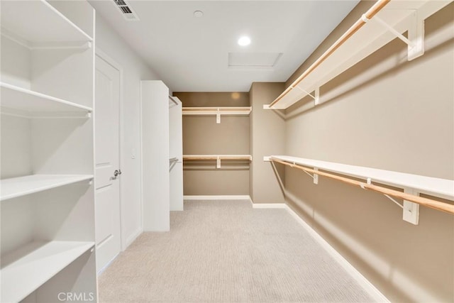 walk in closet with light carpet