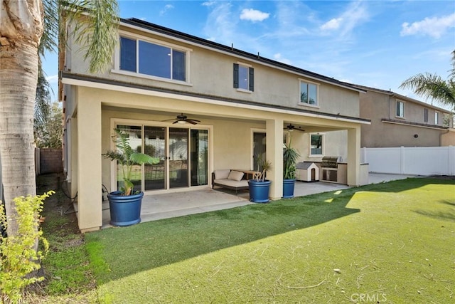 rear view of house with a patio area, area for grilling, ceiling fan, and a lawn