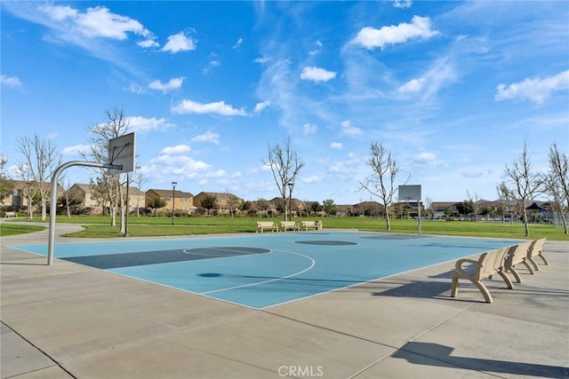 view of basketball court with a yard