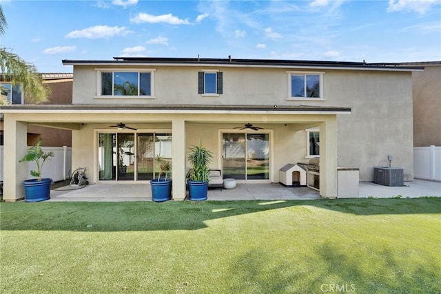 rear view of property with a patio, cooling unit, ceiling fan, and a yard