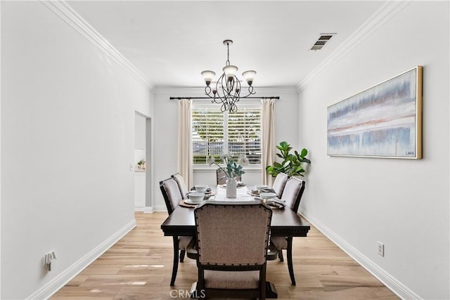 dining space featuring ornamental molding, visible vents, light wood-style floors, and baseboards