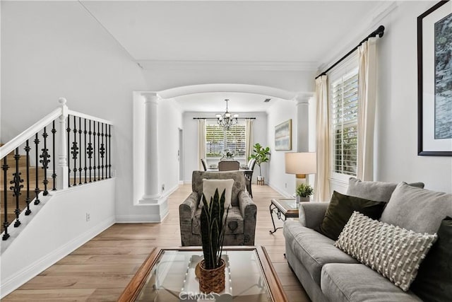 living area featuring a chandelier, arched walkways, wood finished floors, decorative columns, and crown molding