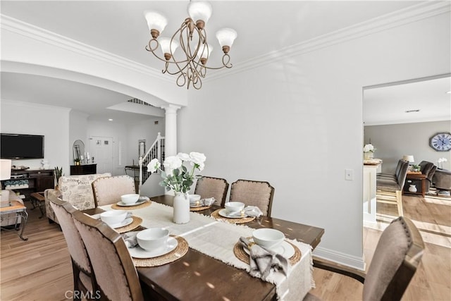 dining space with stairs, ornamental molding, light wood-type flooring, and decorative columns