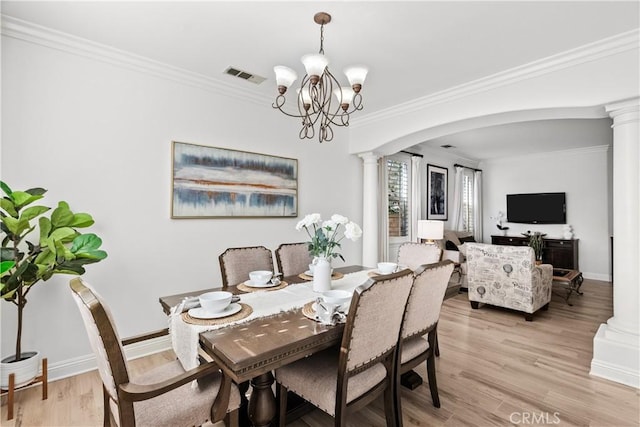 dining room featuring decorative columns, visible vents, arched walkways, and crown molding