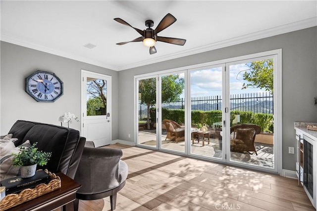 entryway with light wood-type flooring, ornamental molding, and a wealth of natural light