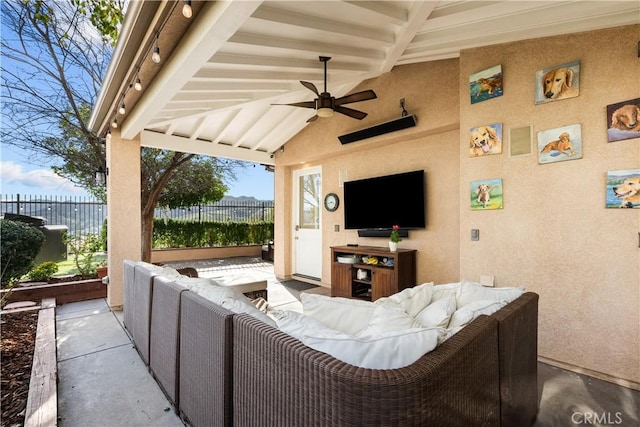 view of patio / terrace featuring ceiling fan, fence, and an outdoor living space