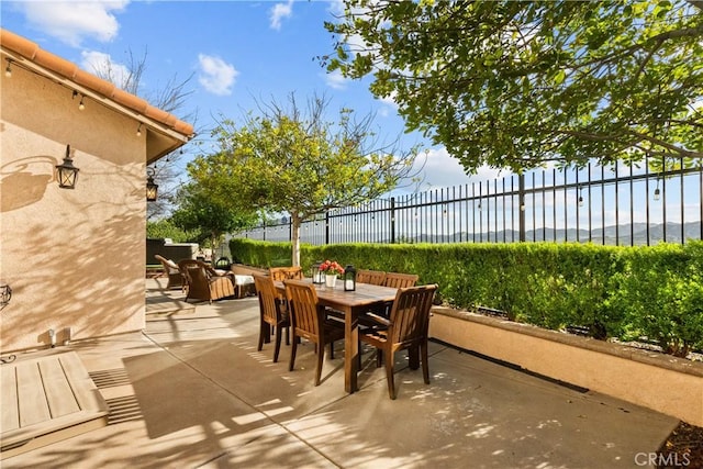 view of patio featuring outdoor dining space and fence