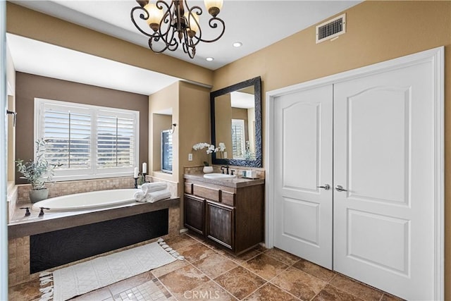 full bath with a bath, vanity, visible vents, and a chandelier