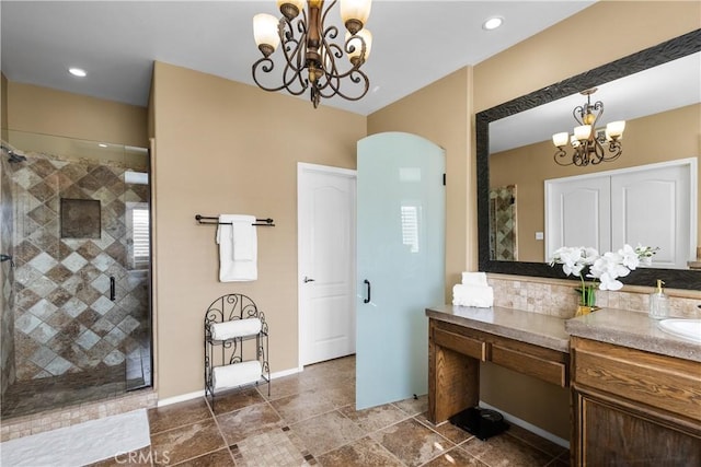 bathroom with recessed lighting, a shower stall, vanity, a chandelier, and baseboards