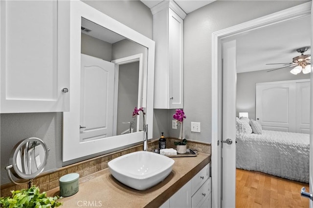 bathroom with visible vents, ensuite bath, ceiling fan, wood finished floors, and vanity