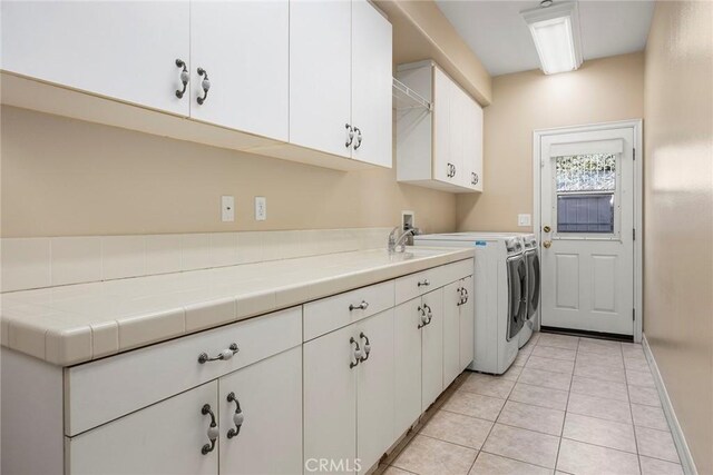 2503 N San Miguel Dr, Orange, CA 92867 - laundry area with washing machine and dryer, cabinet space, light tile patterned floors, and baseboards