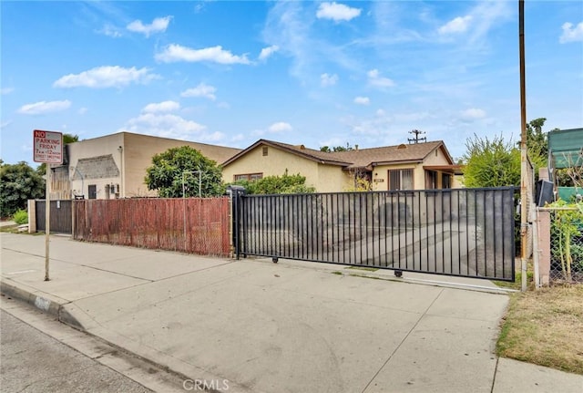 view of front of house featuring a fenced front yard, a gate, and stucco siding