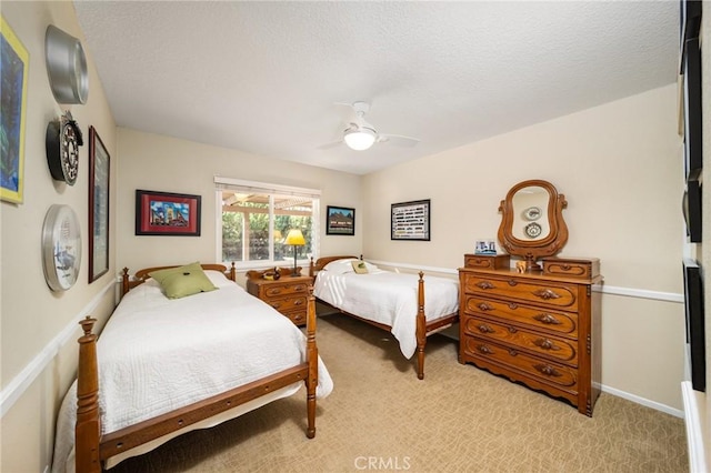 bedroom with a textured ceiling, light carpet, and ceiling fan