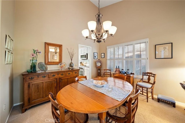 carpeted dining area featuring a notable chandelier and a high ceiling