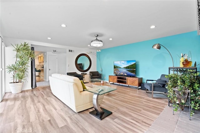 living room featuring light wood finished floors, visible vents, and recessed lighting