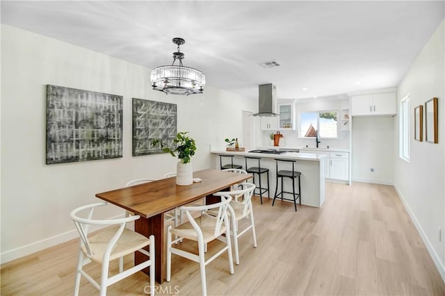 dining space with a notable chandelier and light wood-type flooring