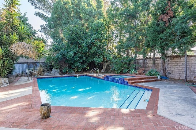 view of pool with an in ground hot tub and a patio