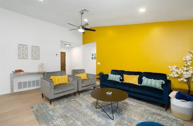 living room with lofted ceiling, ceiling fan, and wood-type flooring