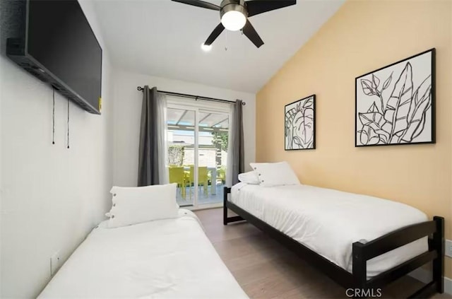 bedroom with vaulted ceiling, ceiling fan, access to exterior, and hardwood / wood-style flooring