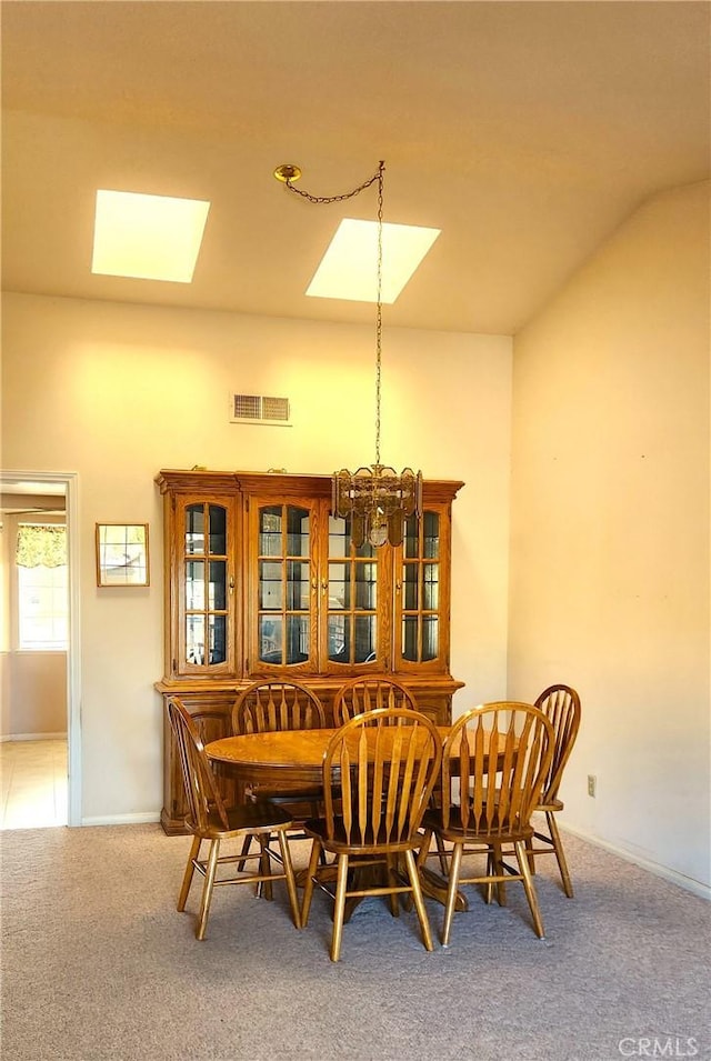 dining space with visible vents, carpet floors, vaulted ceiling, and a chandelier