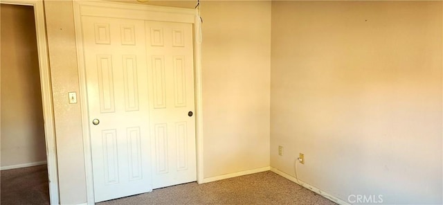 unfurnished bedroom featuring a closet, baseboards, and carpet floors