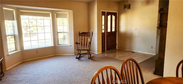 entrance foyer with baseboards, light colored carpet, and light tile patterned flooring