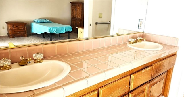 full bath with decorative backsplash, double vanity, and a sink